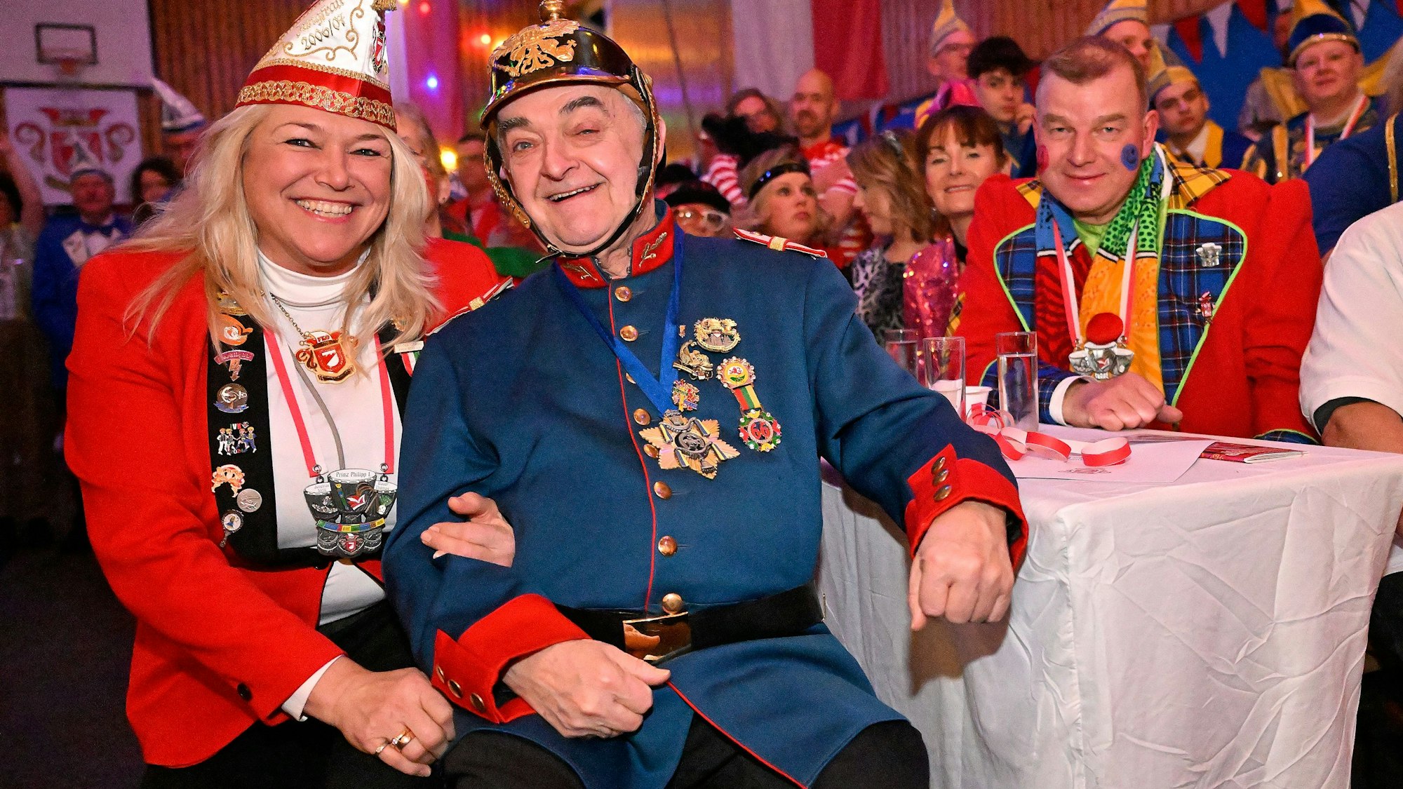 NRW-Innenminister Herbert Reul sitzt mit Tanja Paas vom Festkomitee der Karnevalsfreunde Oberodenthal kostümiert in der Prunksitzung in Oberodenthal.
