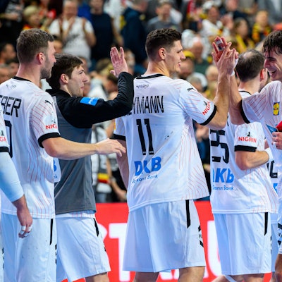 Julian Köster klatscht sich mit dem roten Plüsch-Dom, der Auszeichnung für den Spieler des Spiels mit seinen Kollegen ab.