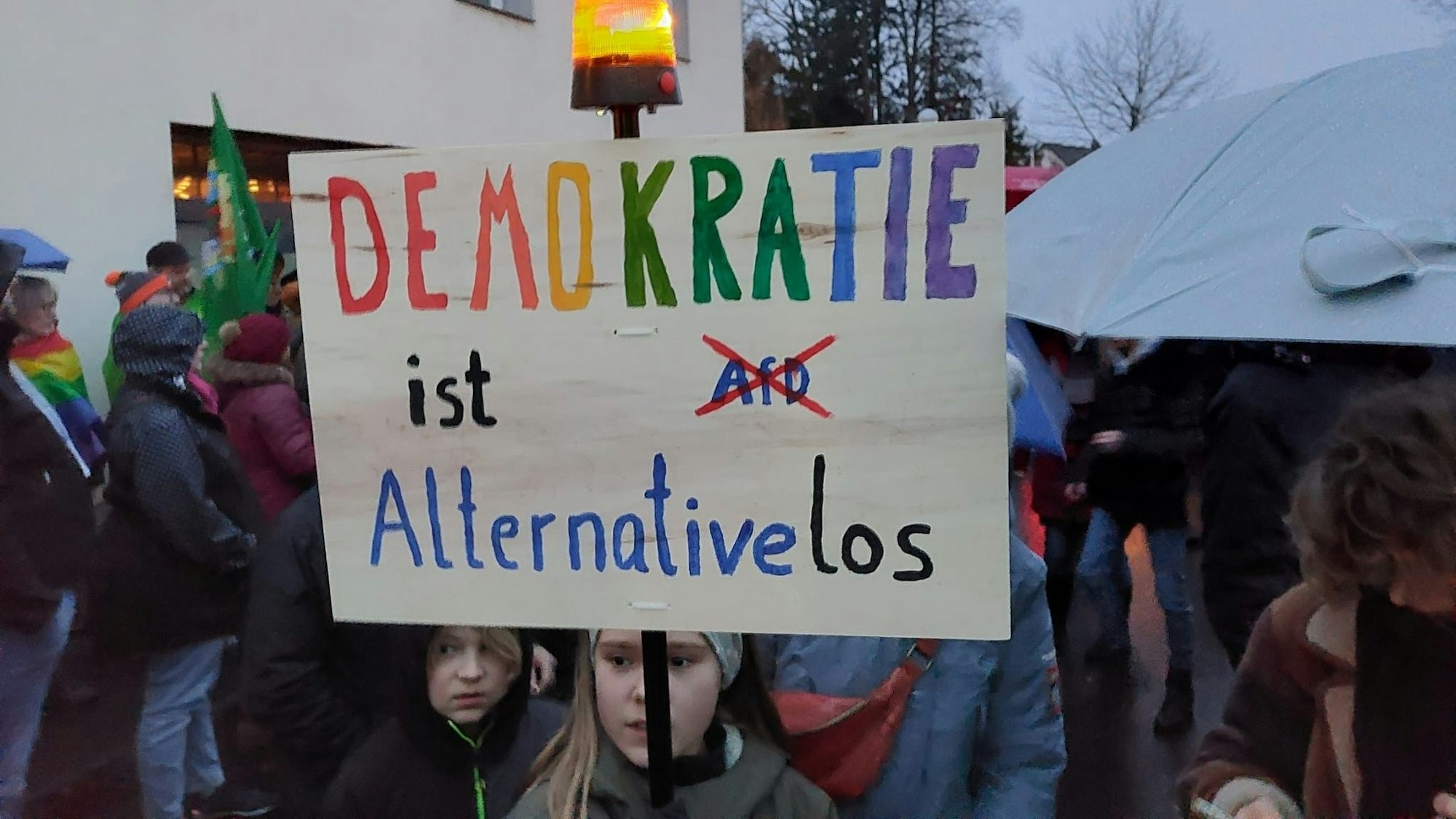 „Demokratie ist Alternativelos“ steht auf einem Schild, das Kinder in die Höhe halten.