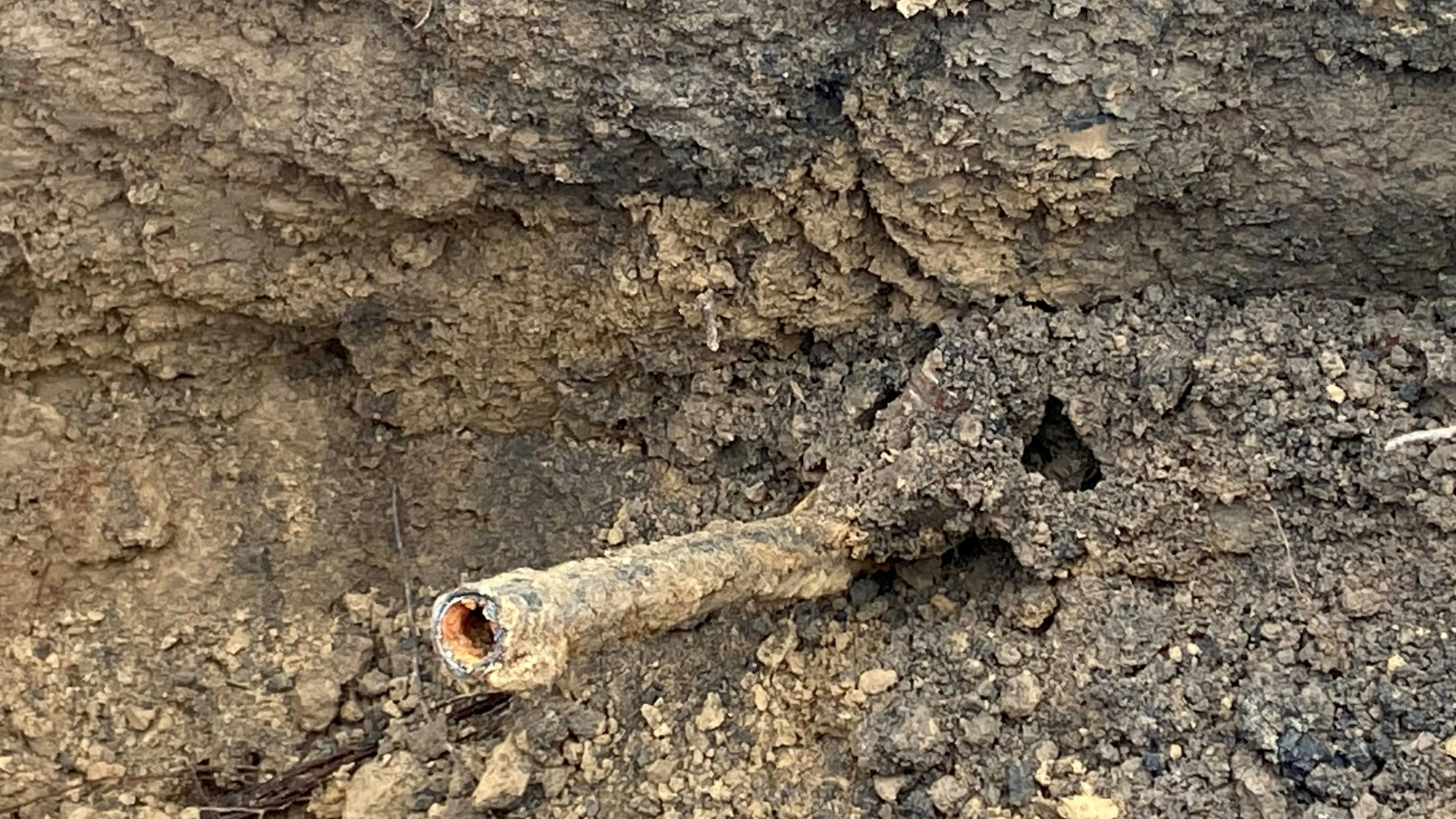 Auf dem Bild ist ein Rohr in einer Baugrube.