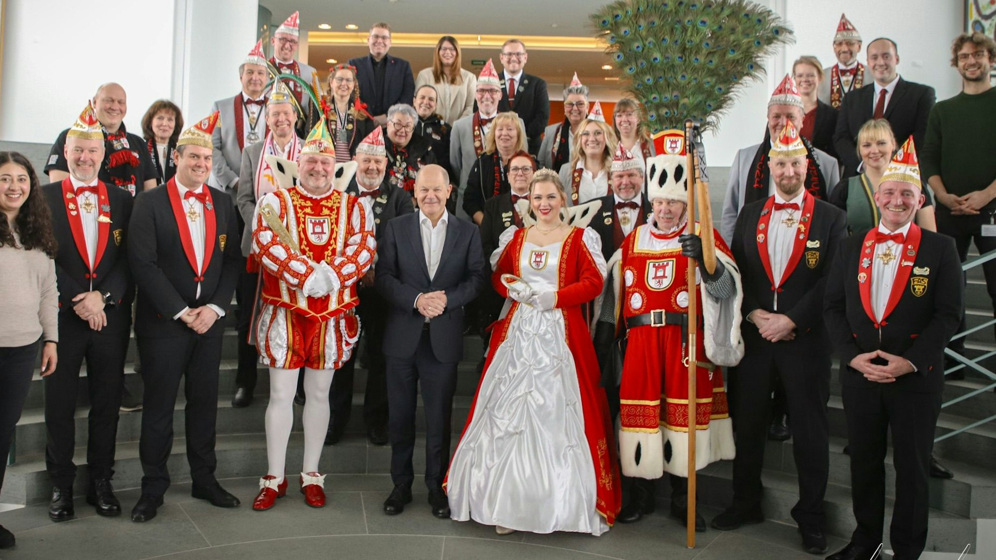 Menschen in Kostümen neben einem Mann im Anzug