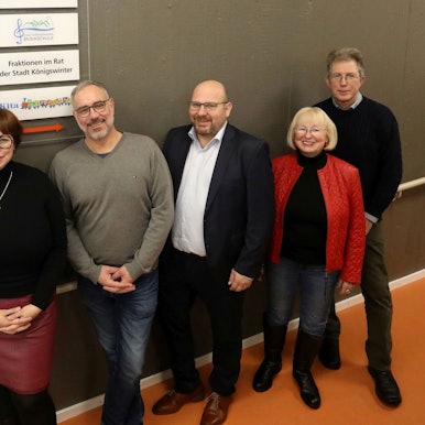 Eine Gruppe von Männern und Frauen stellen sich zum Gruppenfoto.