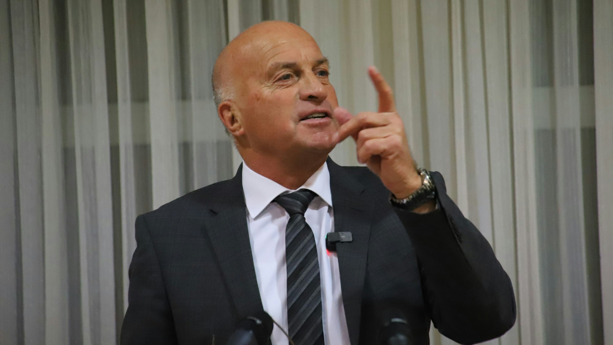 Ein kahlköpfiger Mann gestikuliert.