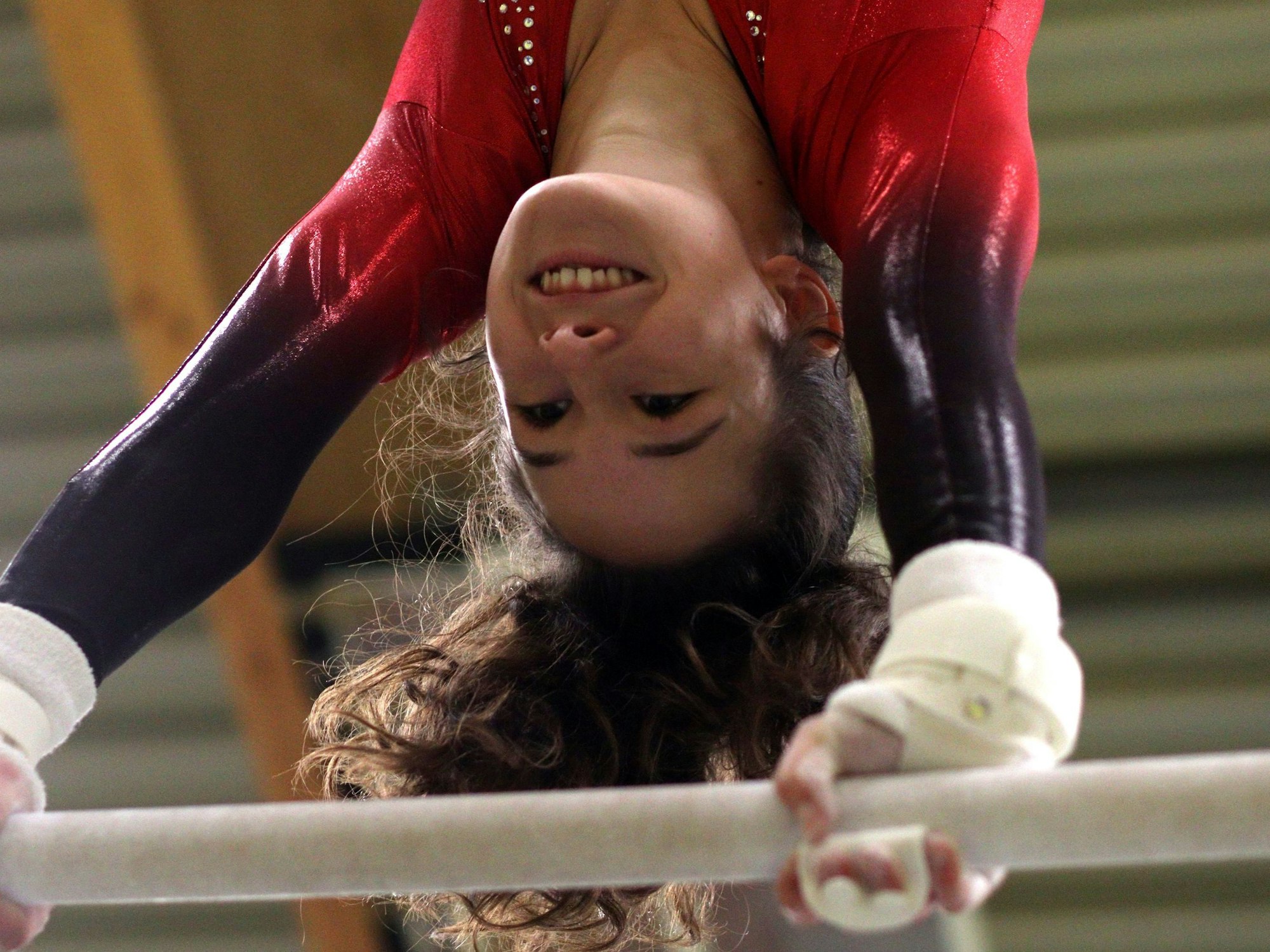 Die Turnerin Anouk Hauser steht kopfüber am Reck.