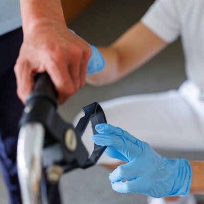 Eine ambulante Pflegefachkraft begleitet einen Bewohner des Betreuten Wohnens mit seiner Gehhilfe durch das Gebäude.