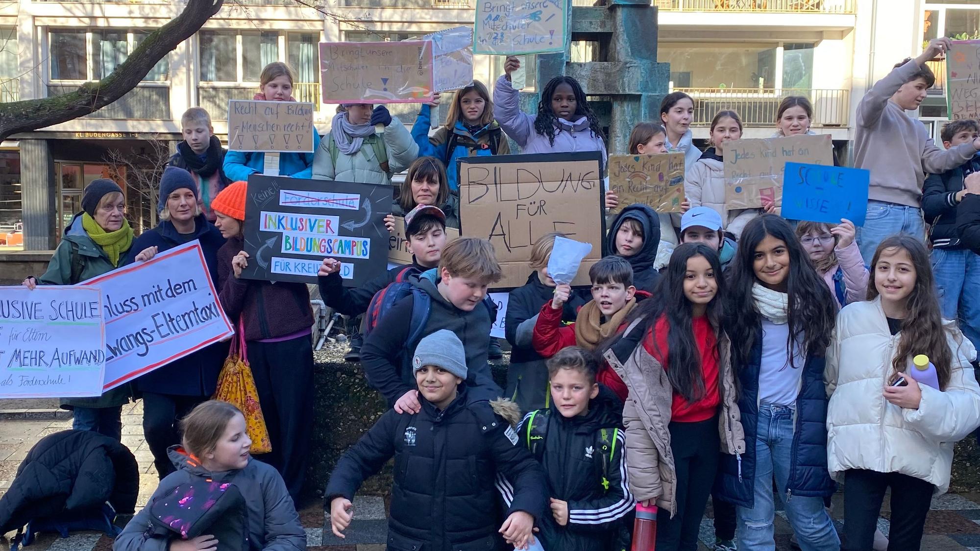 Kinder mit selbst gebastelten Plakaten demonstrieren.