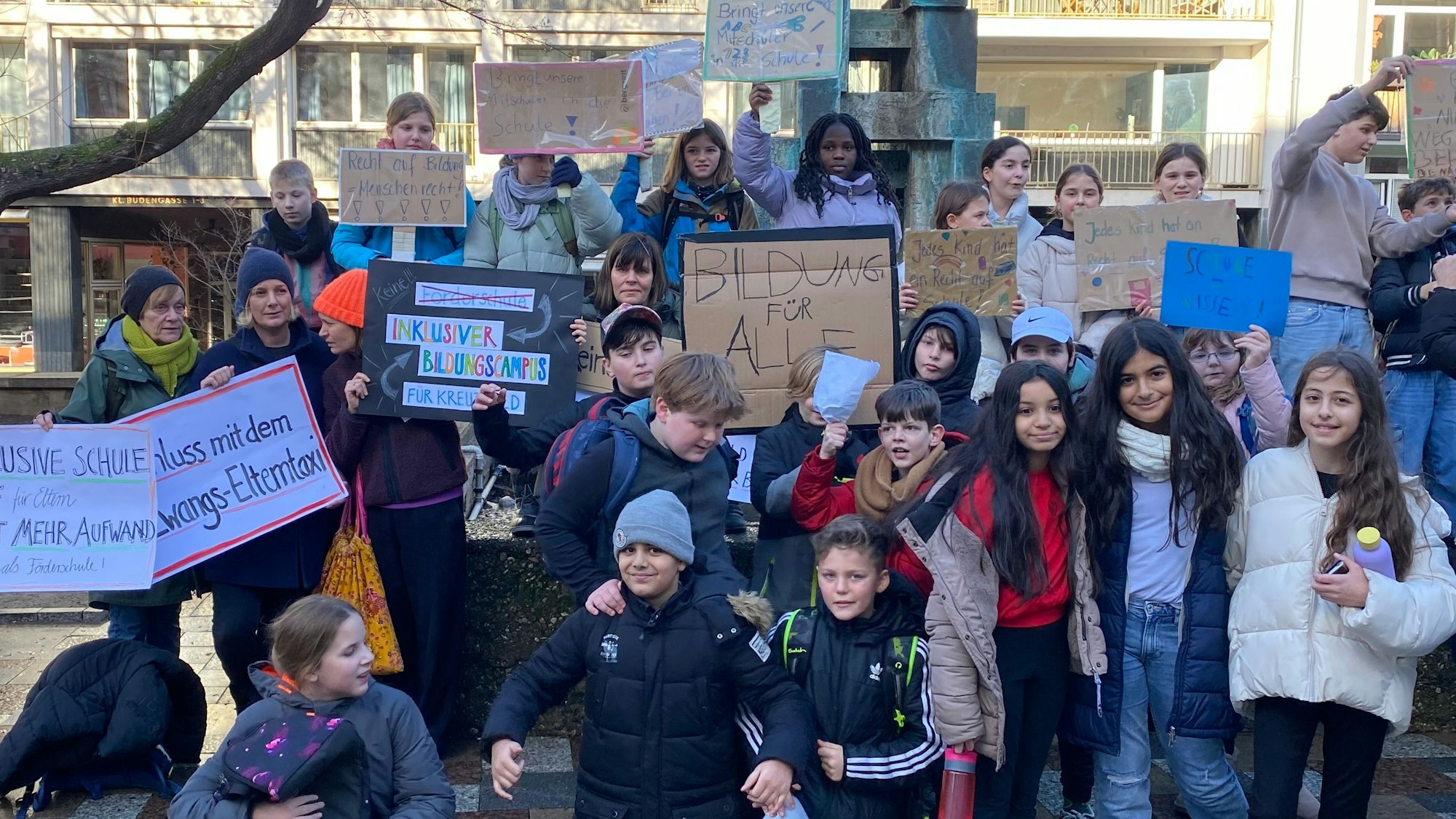 Kinder mit selbst gebastelten Plakaten demonstrieren.