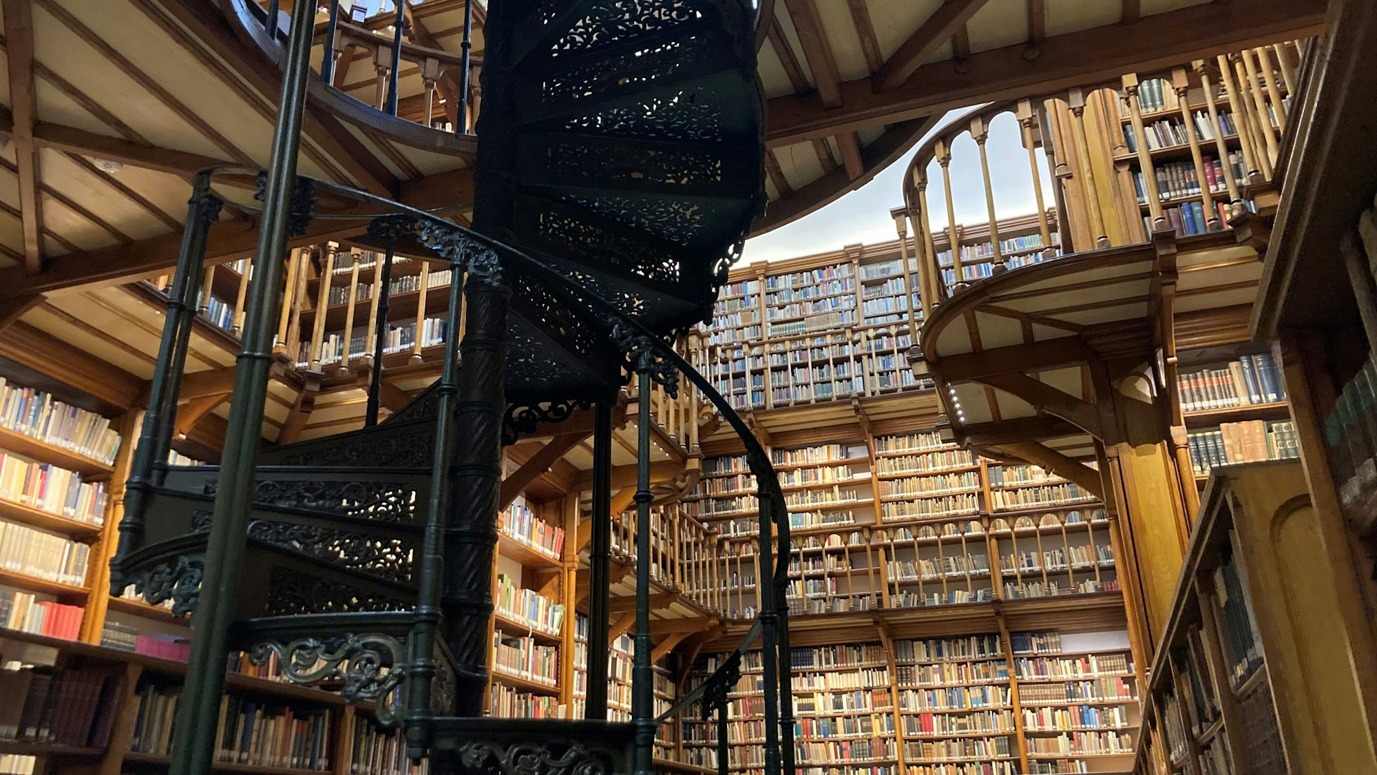 Holzbalustraden und Tausende alter Bücher reichen bis unter die Decke der Bibliothek.