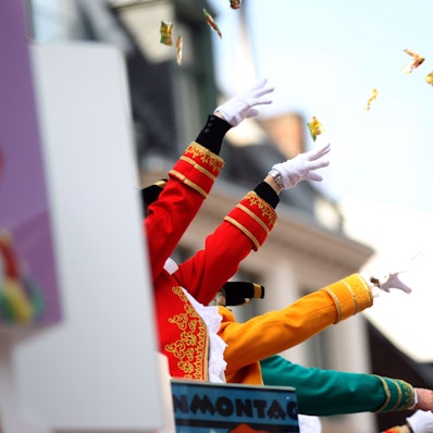 Von einem Karnevalswagen werden Kamelle geworfen.