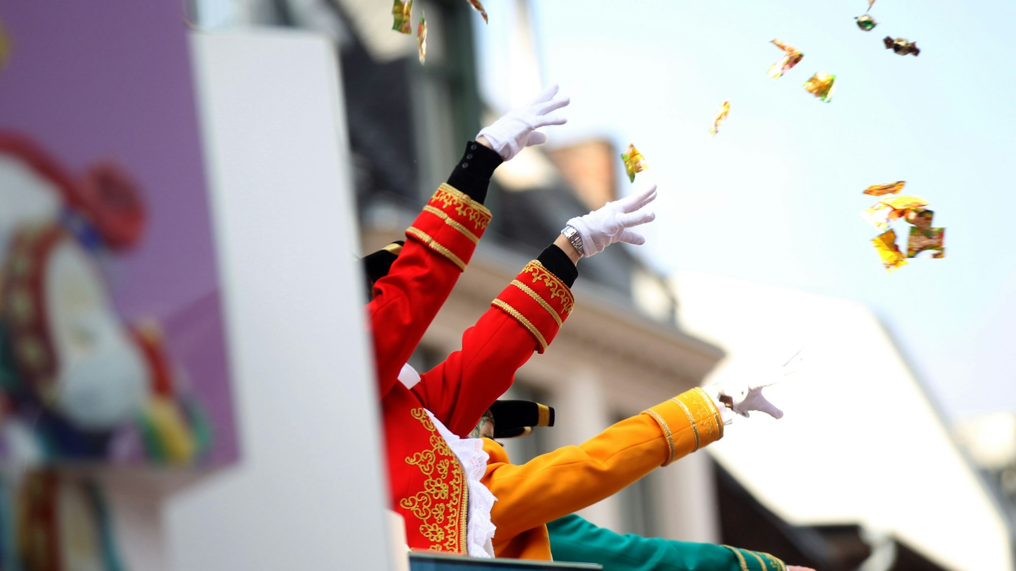 Von einem Karnevalswagen werden Kamelle geworfen.