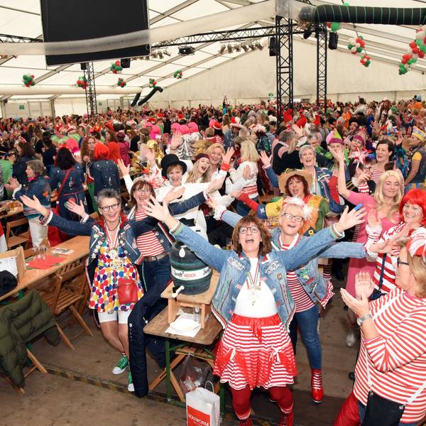 Ein volles Festzelt. Zahlreiche verkleidete Damen feiern Karneval.