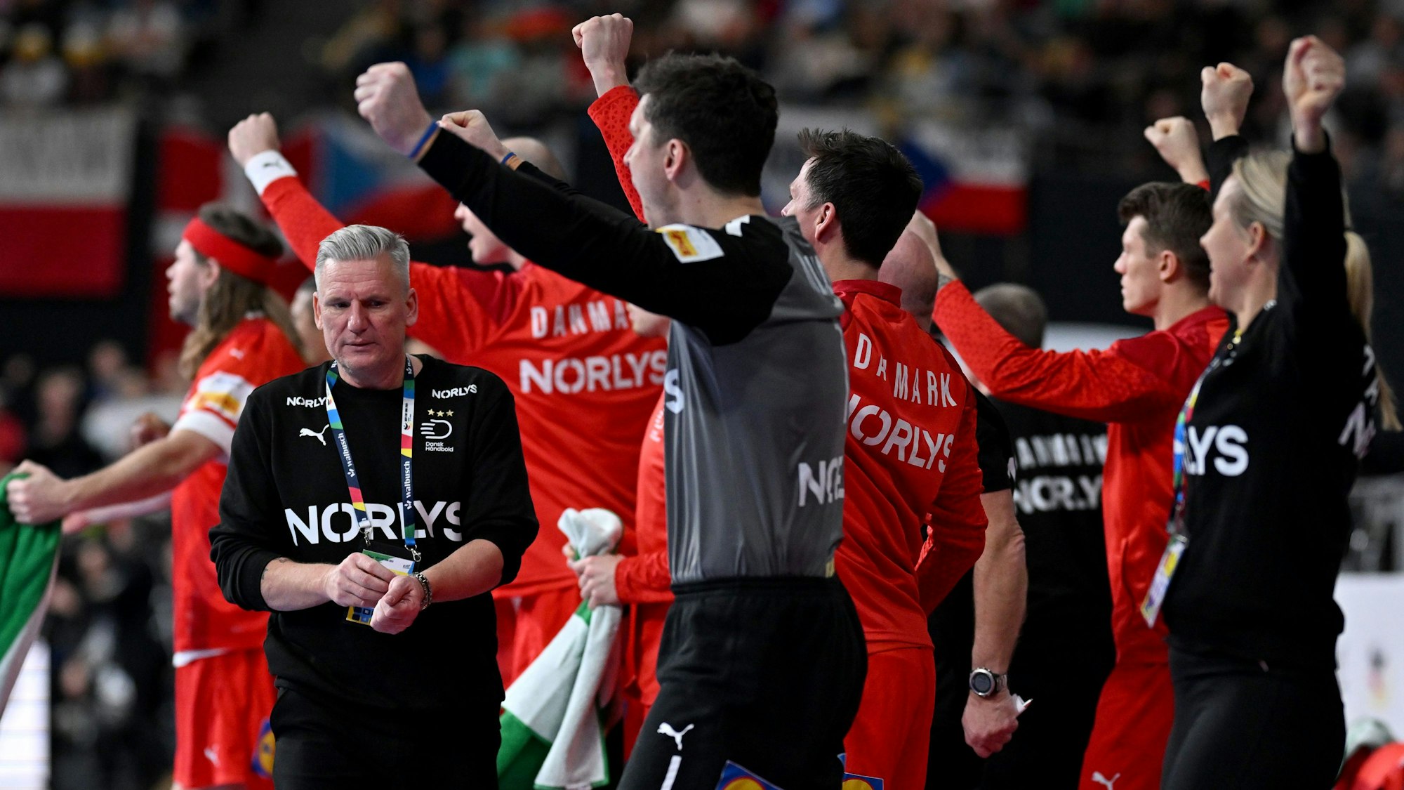 Dänemarks Trainer Nikolaj Jacobsen (l), Dänemarks Torhüter Niklas Landin (M) sowie weitere Wechselspieler und Betreuer jubeln am Spielfeldrand beim Vorrunden-Sieg gegen Tschchien.