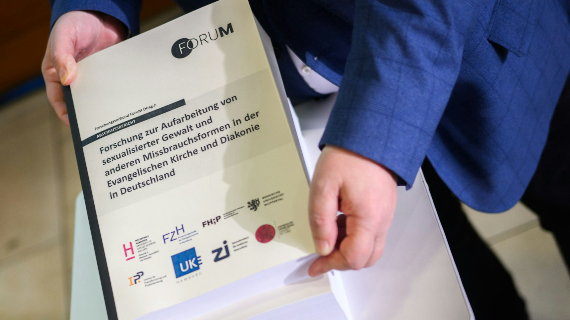 Detlev Zander, Mitglied im Beirat des Forschungsverbundes und Sprecher der Betroffenenvertretung im Beteiligungsforum der EKD, zeigt in Hannover das Ergebnis einer Studie zum Missbrauch in der evangelischen Kirche.