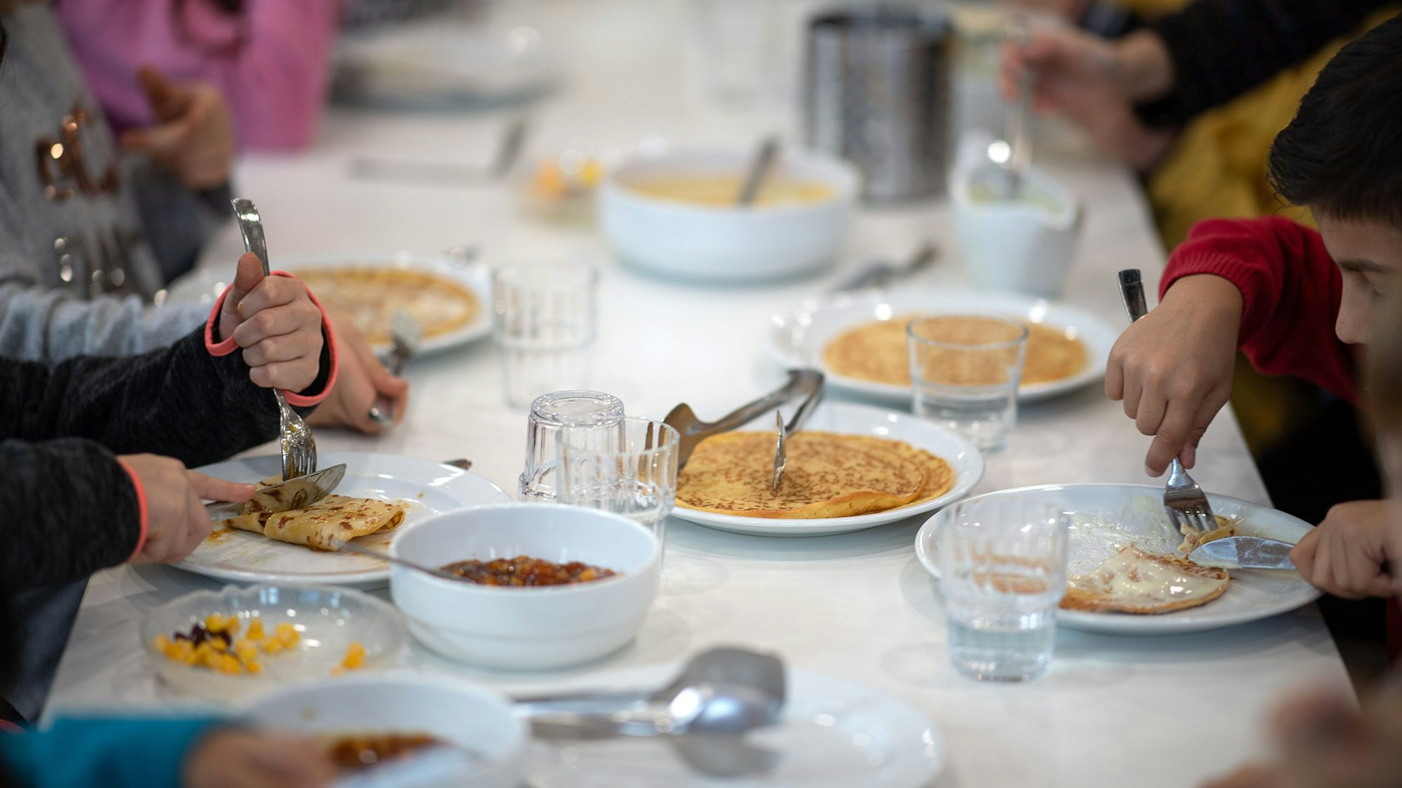 Das Bild zeigt Kinder, die in der Kantine einer Grundschule zu Mittag essen. Foto: Sebastian Gollnow/dpa