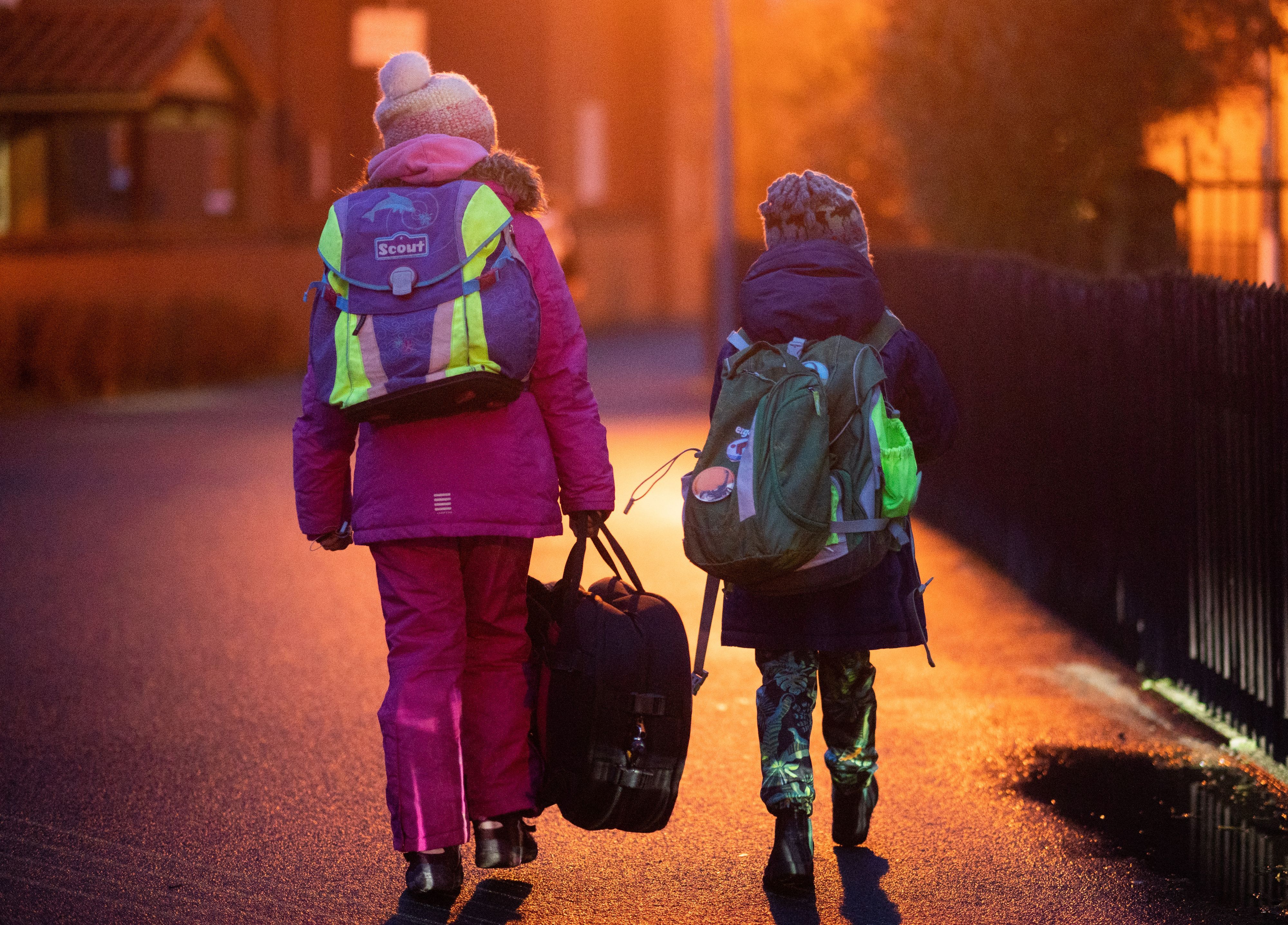 Zwei Schülerinnen in der Morgendunkelheit auf dem Weg zu Schule.