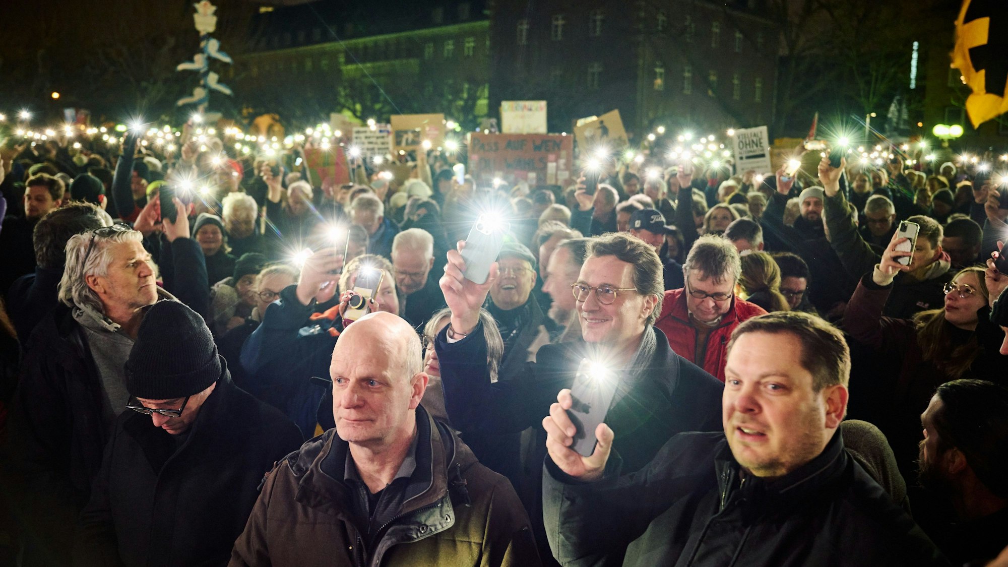 NRW-Ministerpräsident Hendrik Wüst hält bei einer Demo gegen die AfD ein Handylicht hoch.