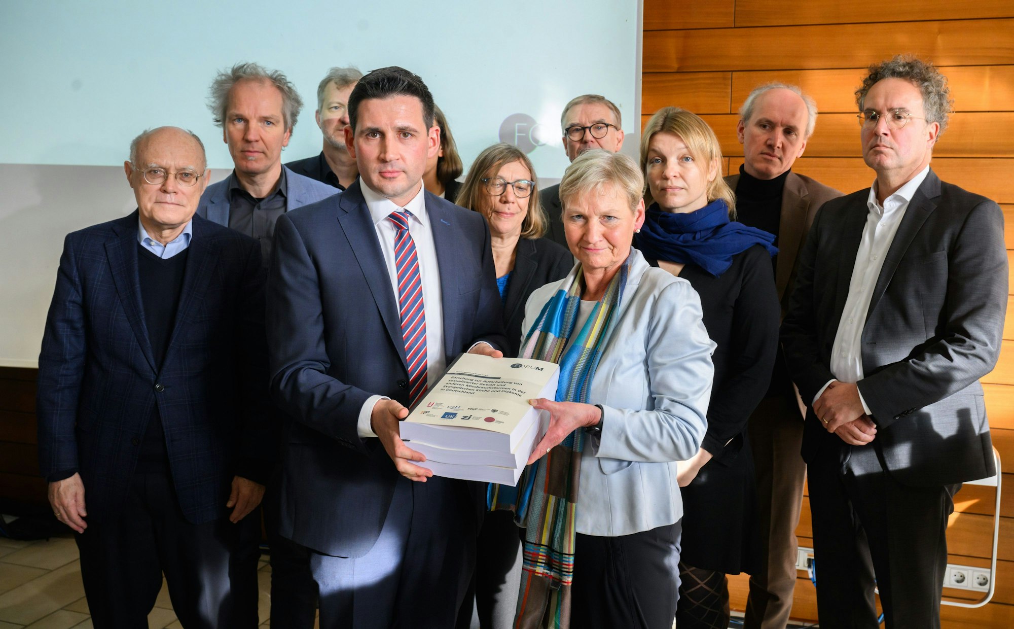 Martin Wazlawik, Koordinator des Forschungsverbundes ·ForuM·, übergibt in Hannover bei einer Pressekonferenz eine Studie zum Missbrauch in der evangelischen Kirche an Kirsten Fehrs, amtierende Vorsitzende des Rates der EKD.