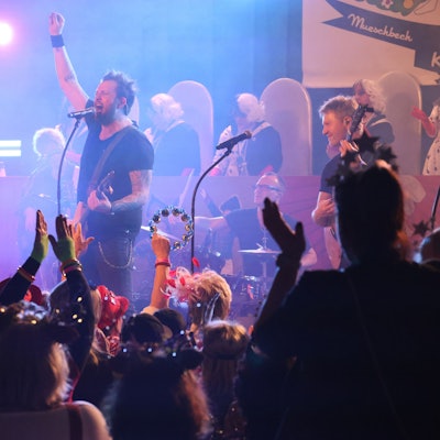 Die Band Paveier spielt auf einer Bühne in einem Karnevalsfestzelt.