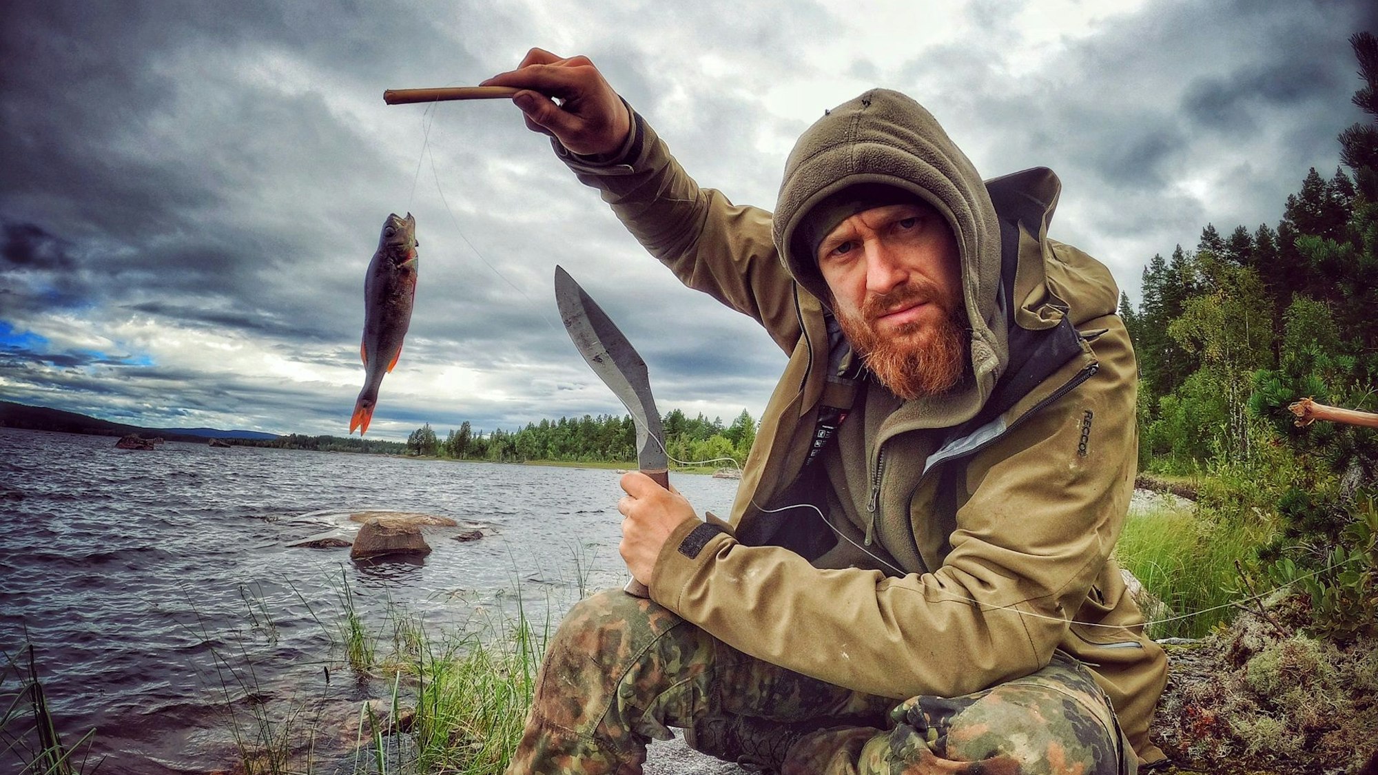 Fritz Meinecke beim Angeln. Er hält einen Fisch in die Höhe.