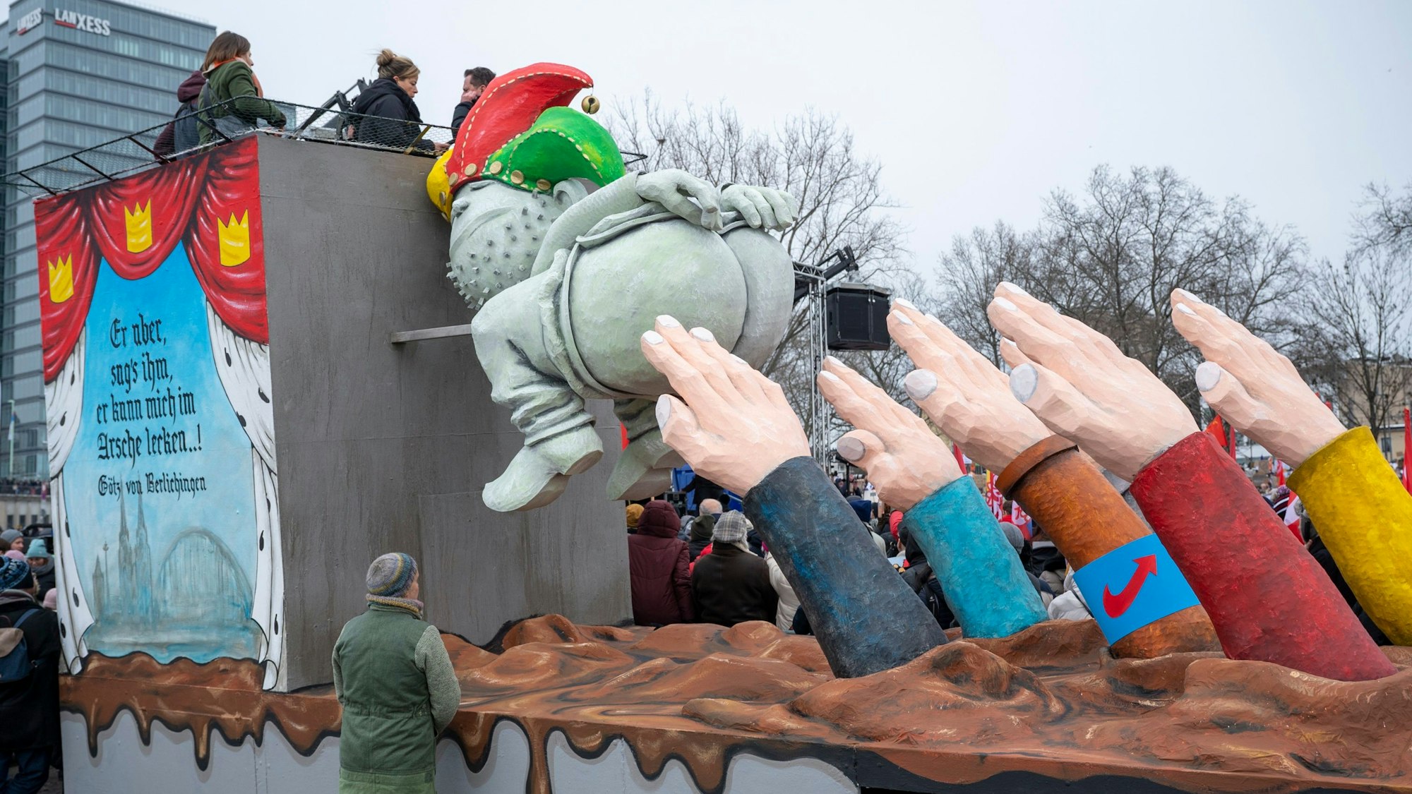 Ein Persiflagewagen zeigt eine Figur, die ihren Po auf Hände richtet, die einen Hitlergruß machen.