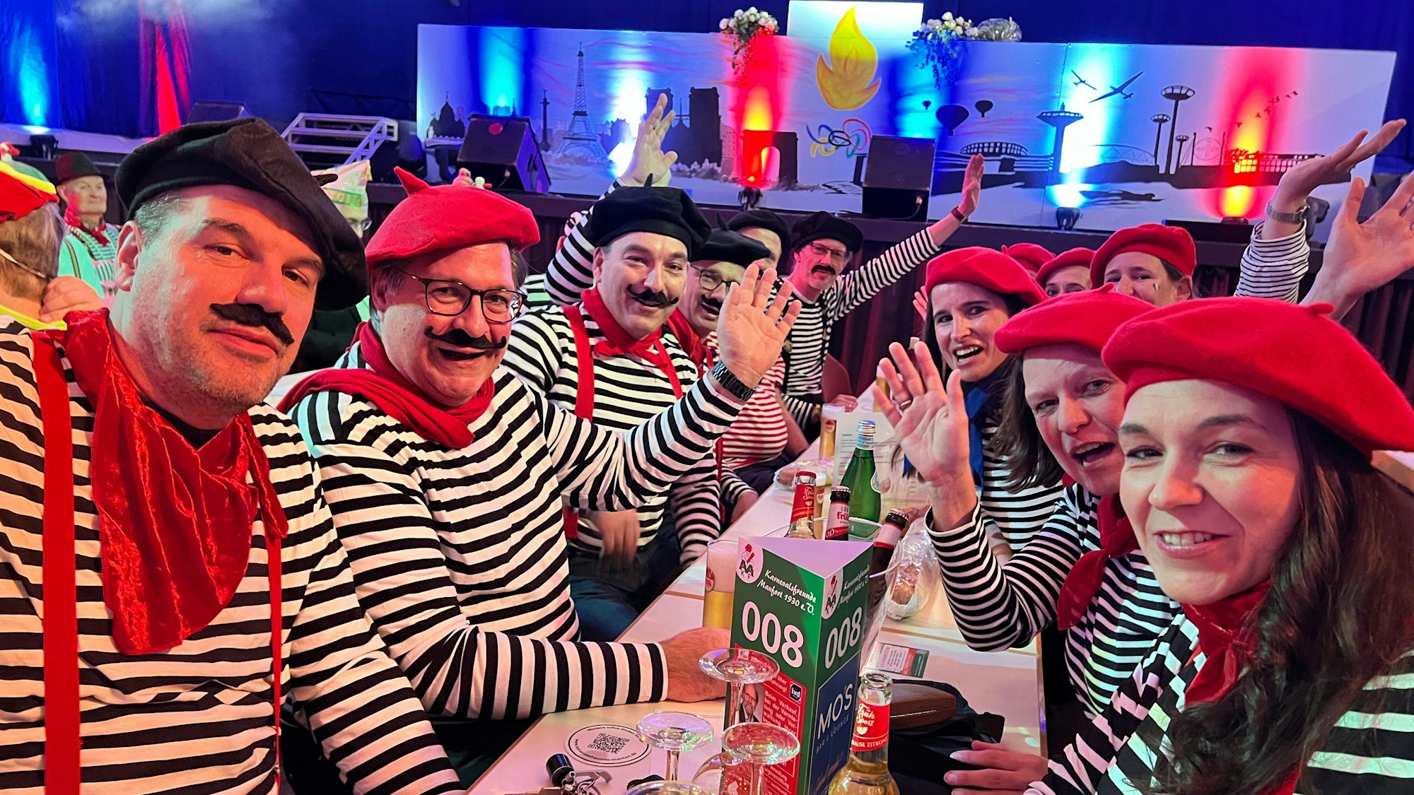 Verkleidete Menschen sitzen an einem Tisch.