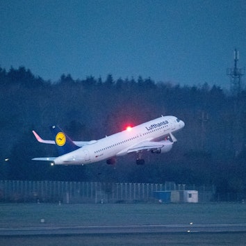 Ein Airbus A320 der deutschen Fluggesellschaft Lufthansa beim Start kurz nach dem Abheben vom Rollfeld. Im Hintergrund leuchtet eine rote Warnlampe. (Symbolbild)