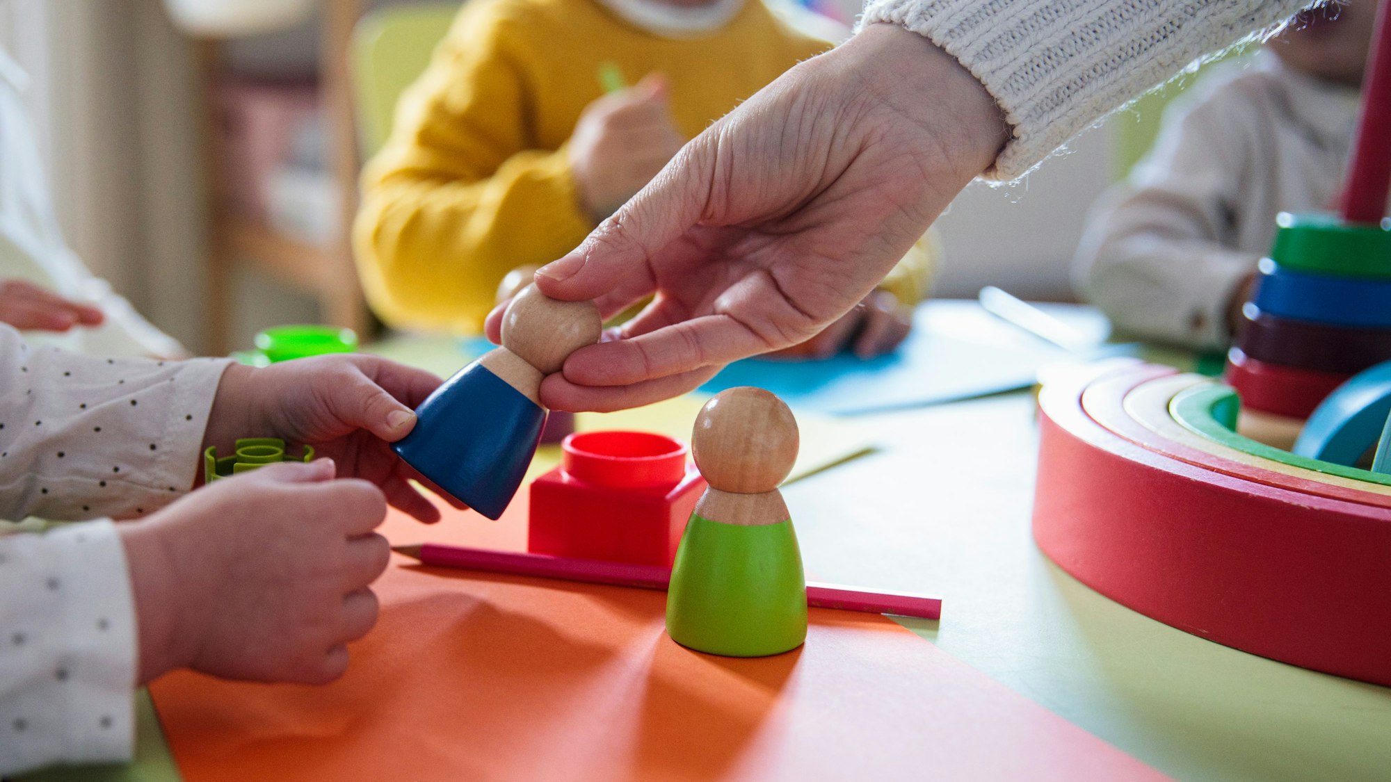 Kinder spielen mit Holzfiguren im Kindergarten
Getty Images / Lourdes Balduque