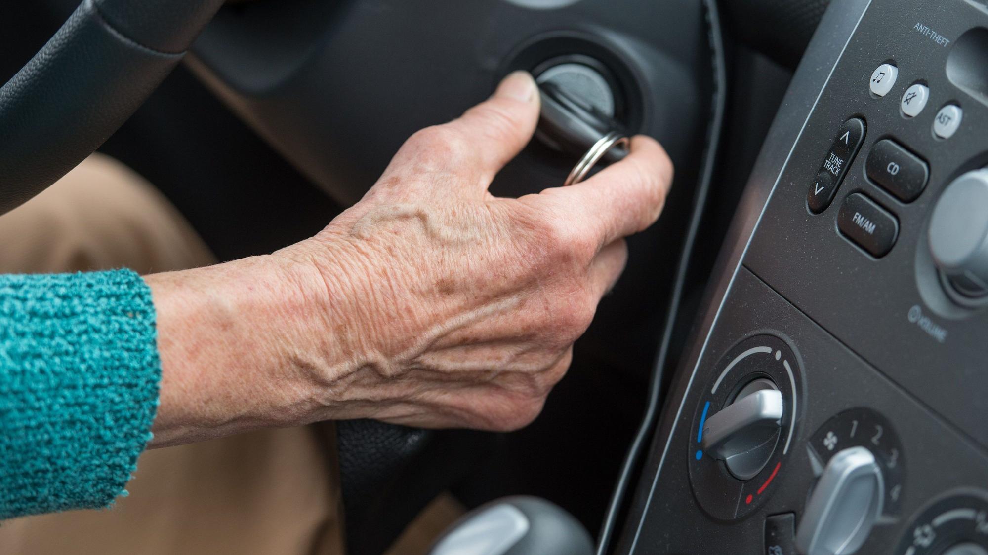 Das Symbolbild zeigt die Hand einer älteren Frau, die mit dem Zündschlüssel ihr Auto startet.