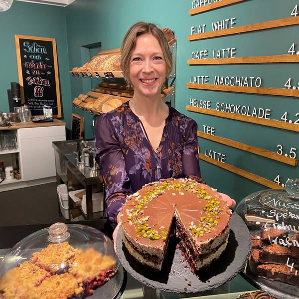 Auf dem Bild ist die Inhaberin des neuen Cafes mit einem Kuchen zu sehen