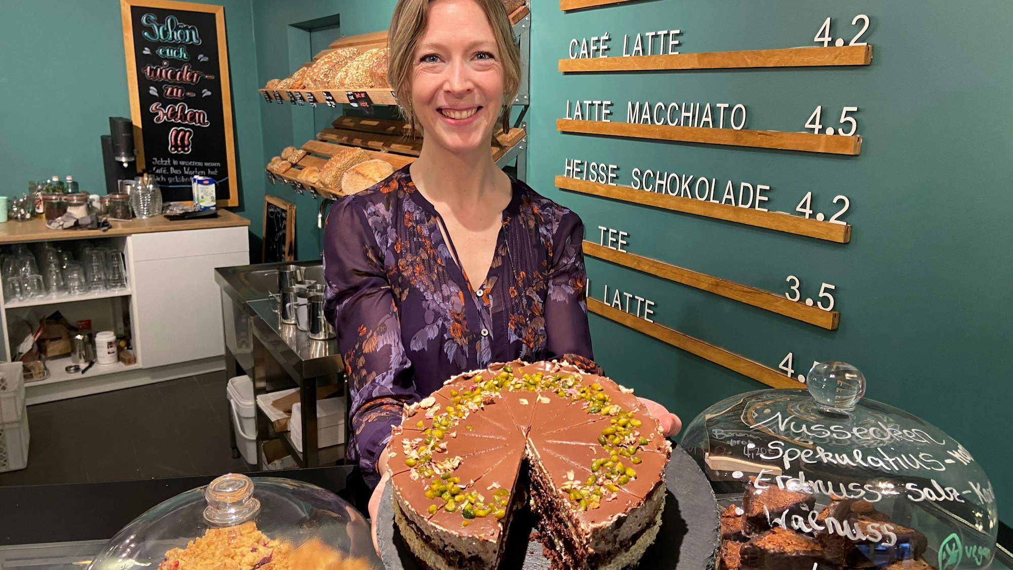 Auf dem Bild ist die Inhaberin des neuen Cafes mit einem Kuchen zu sehen