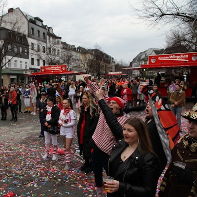 Kostümierte Jecke feiern auf einem Marktplatz