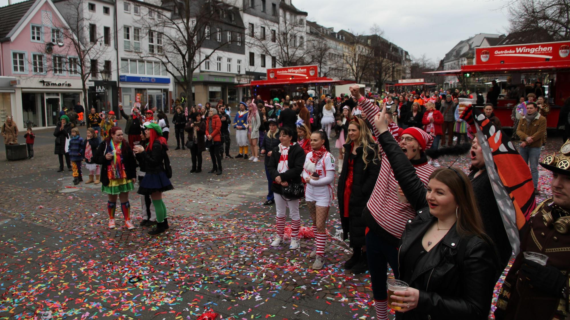 Kostümierte Jecke feiern auf einem Marktplatz