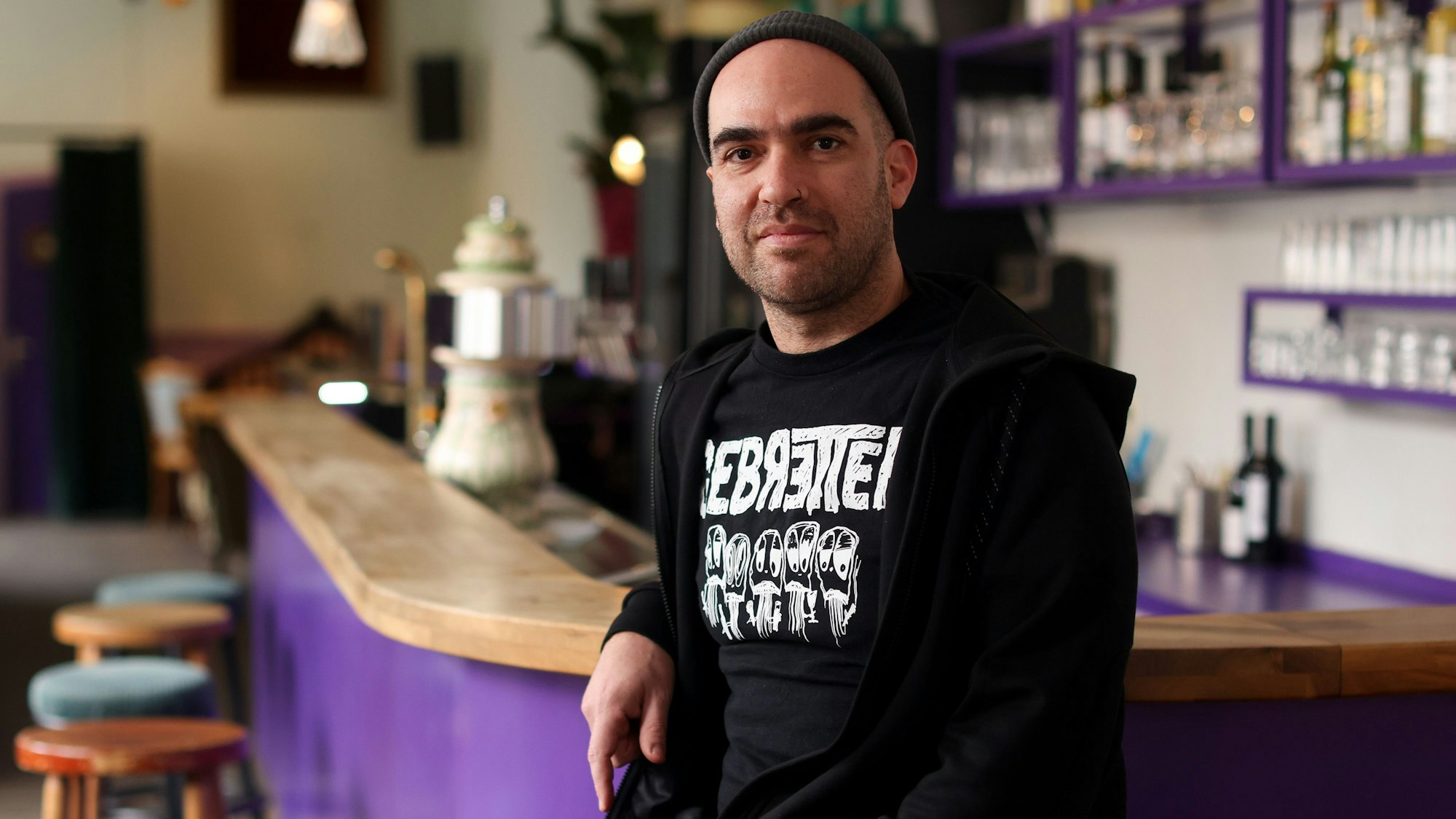 Zu sehen ist Bar-Betreiber Assaf Eldar an der lila Bartheke.