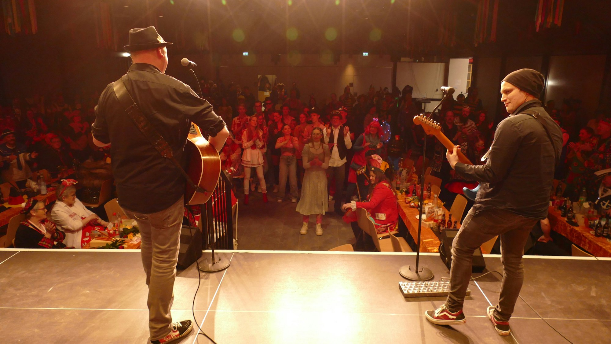 Zwei Männer mit Gitarren stehen auf der Bühne.