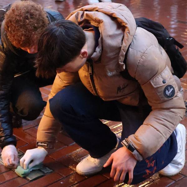 Zwei Schüler reinigen Stolpersteine in der Opladener Fußgängerzone.