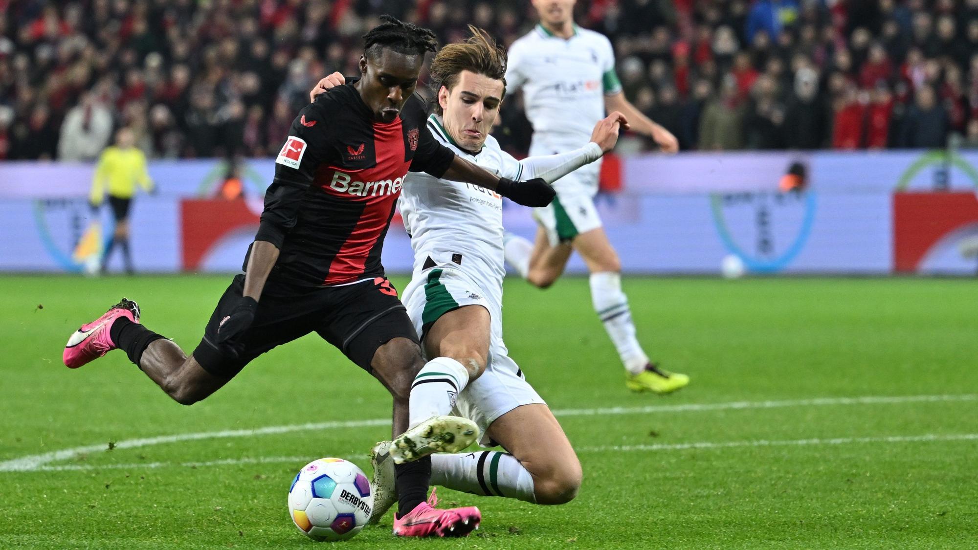 Leverkusens Jeremie Frimpong (l) und Mönchengladbachs Florian Neuhaus kämpfen um den Ball.
