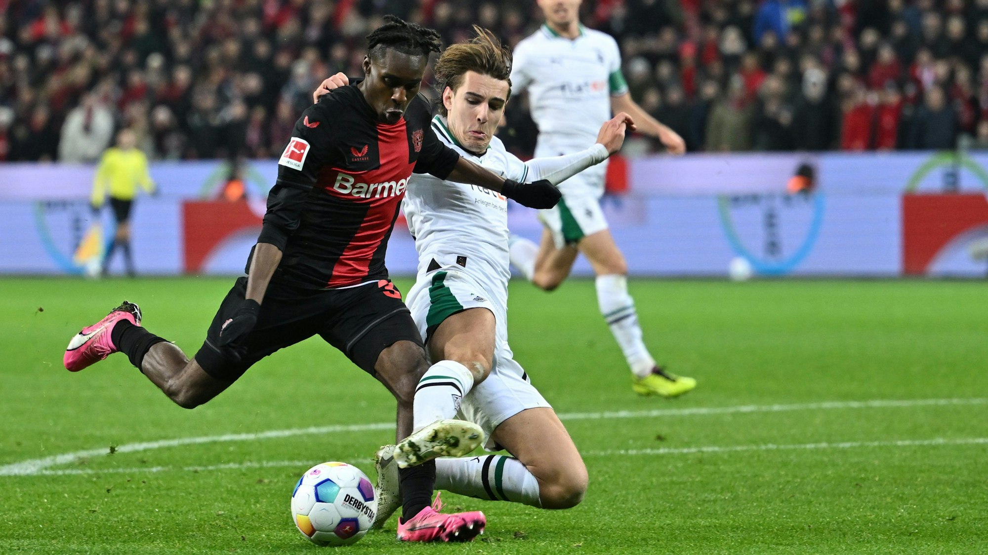 Leverkusens Jeremie Frimpong (l) und Mönchengladbachs Florian Neuhaus kämpfen um den Ball.