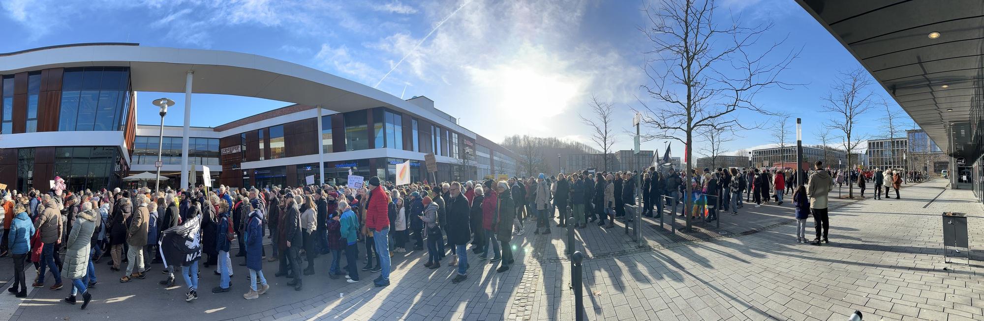 Menschen gehen in einer langen Schlange über die Straße.