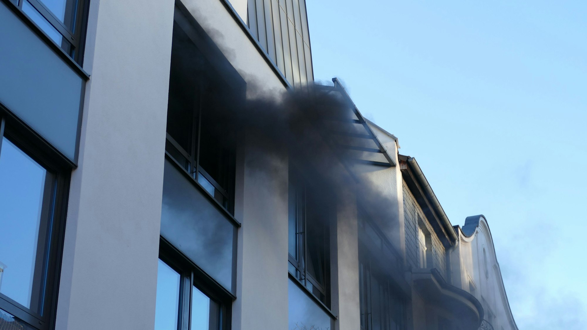 Rauch dringt aus einem Fenster.