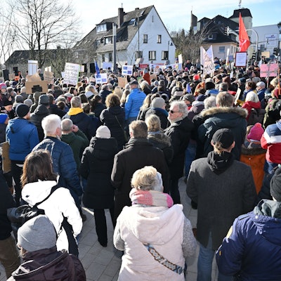 Menschen stehen mit Plakaten dicht gedrängt auf dem Rösrather Sülztalplatz.