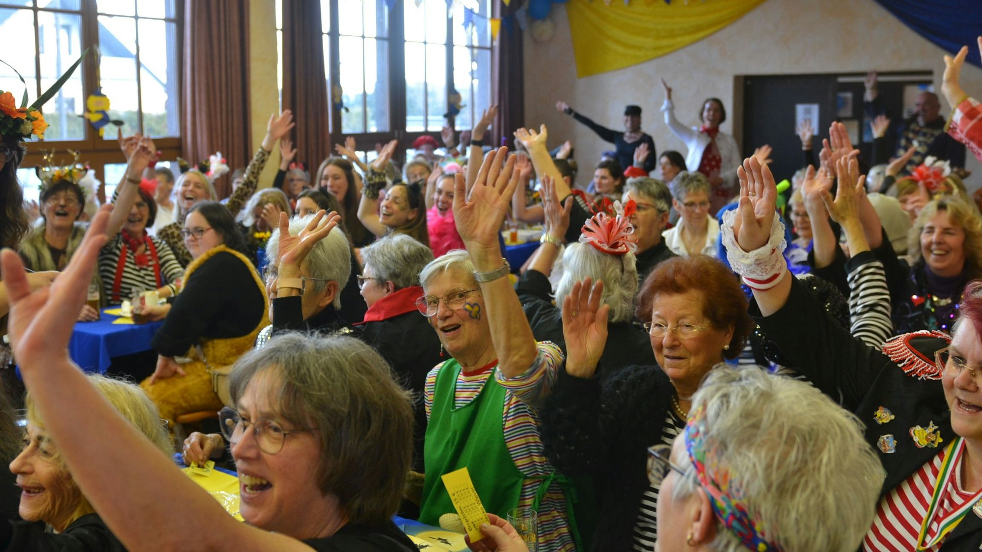 Das Bild zeigt einen Saal voller kostümierter Frauen.