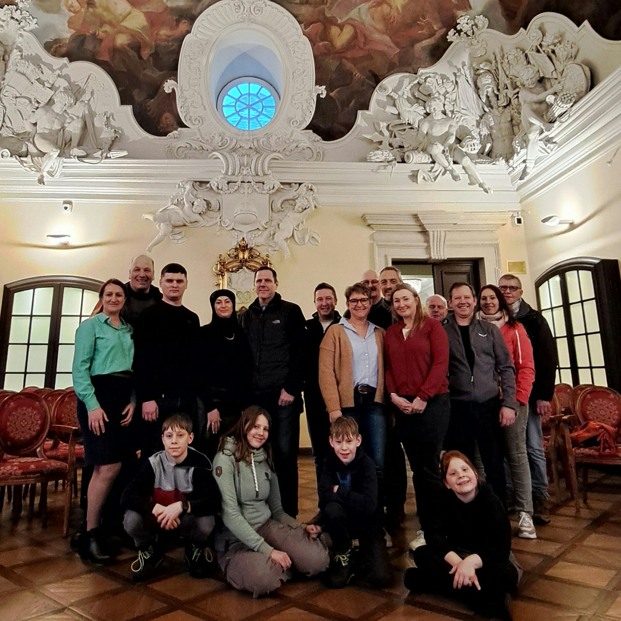 Menschen stehen im Zanetti-Saal von Schloss Bensberg.