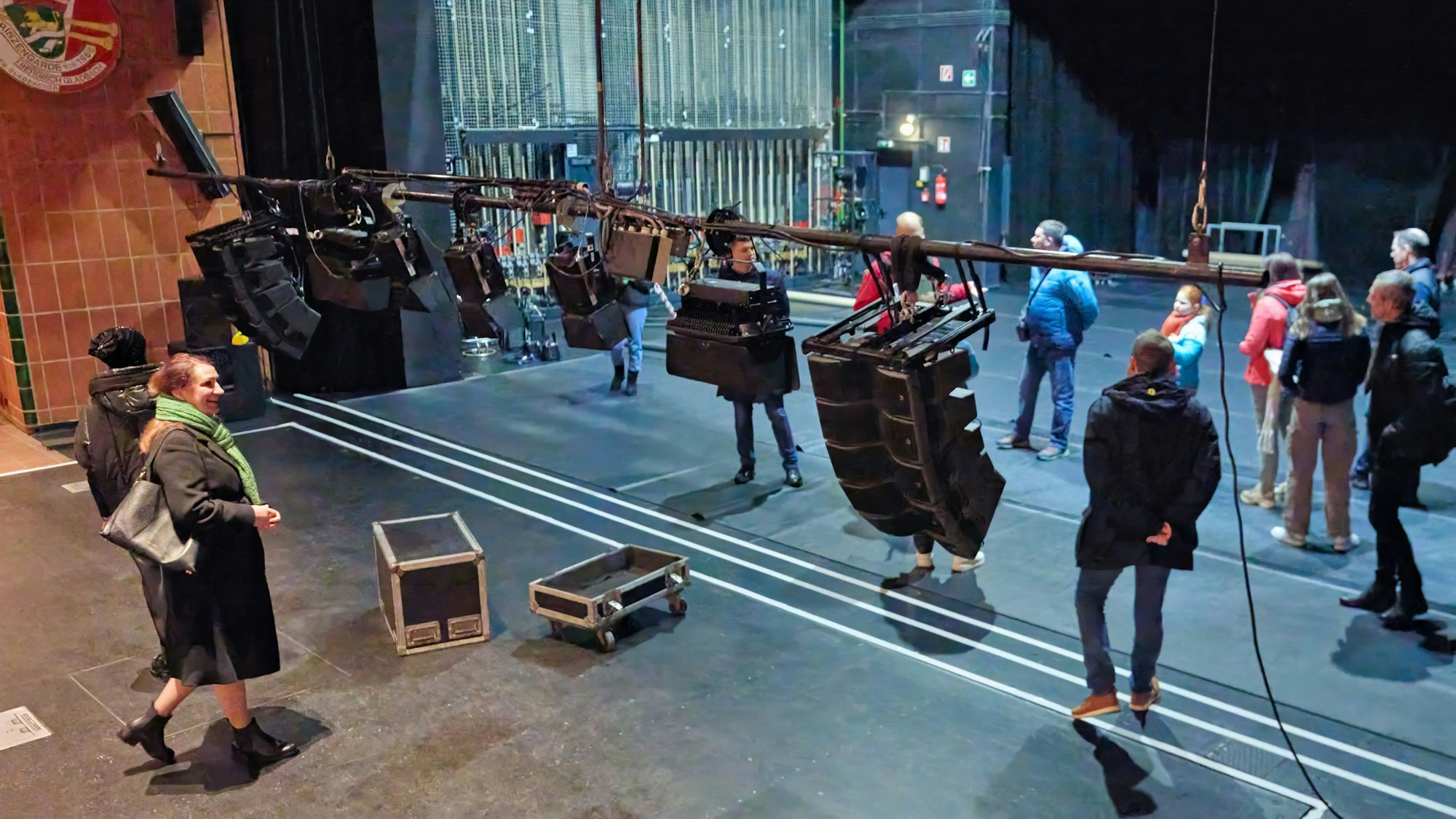 Menschen gehen über die leere Bühne des Bürgerhauses Bergischer Löwe.