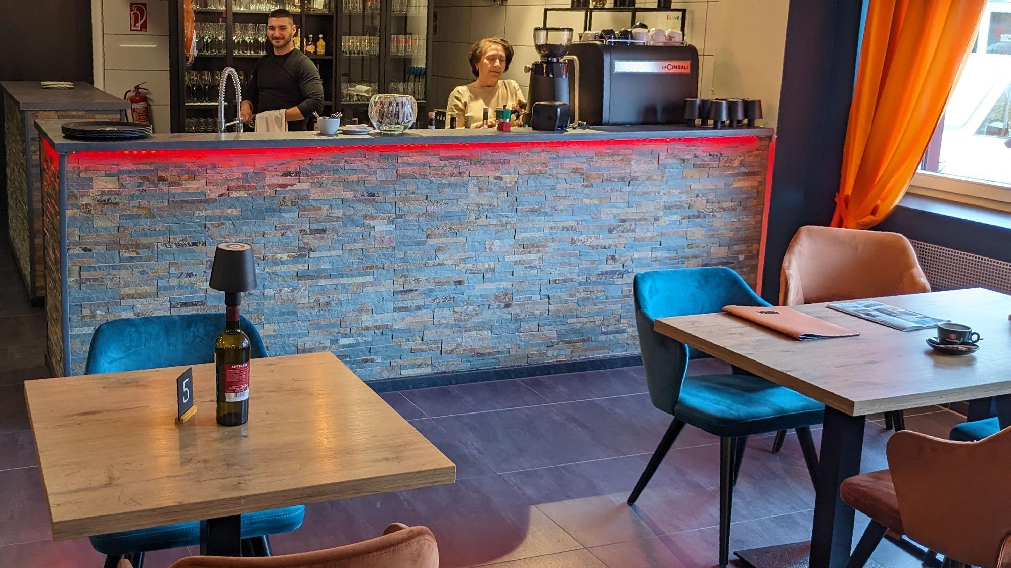 Blick in den Gastraum des Bistro Lenti in Kommern. Riccardo Proietto und Stella Lenti stehen hinter der Theke.