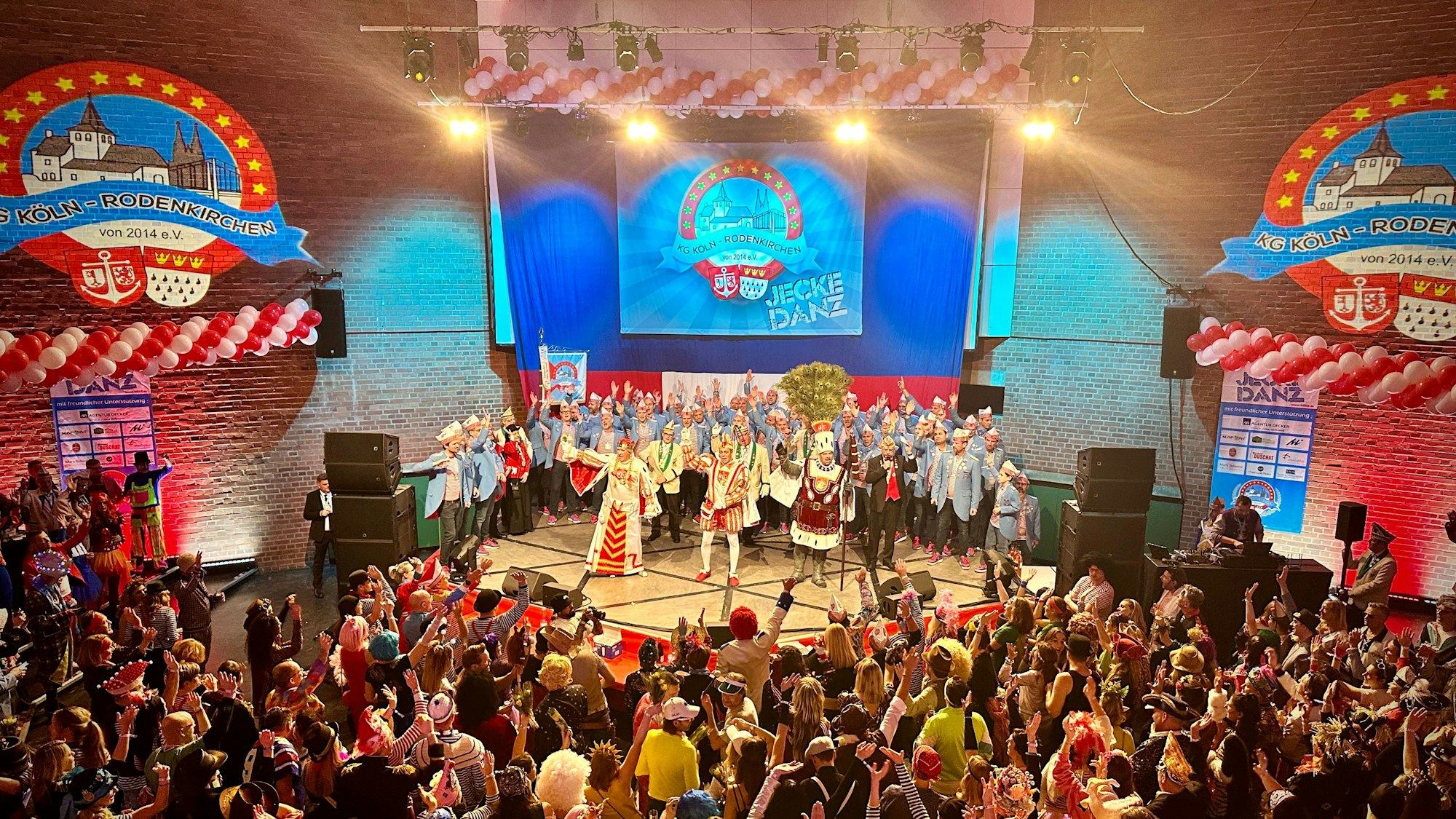 In der Aula steht das Dreigestirn auf der Bühne.