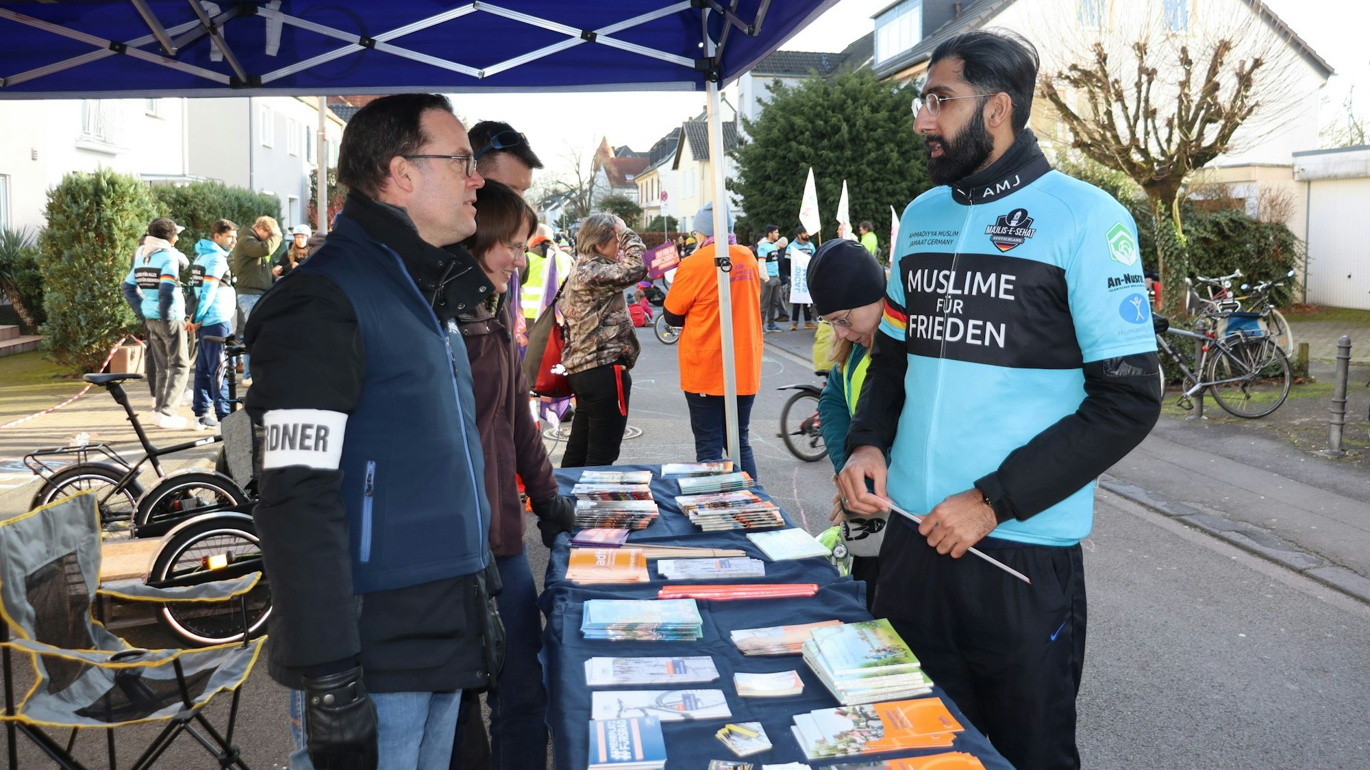 Zwei Männer unterhalten sich an einem Stand.
