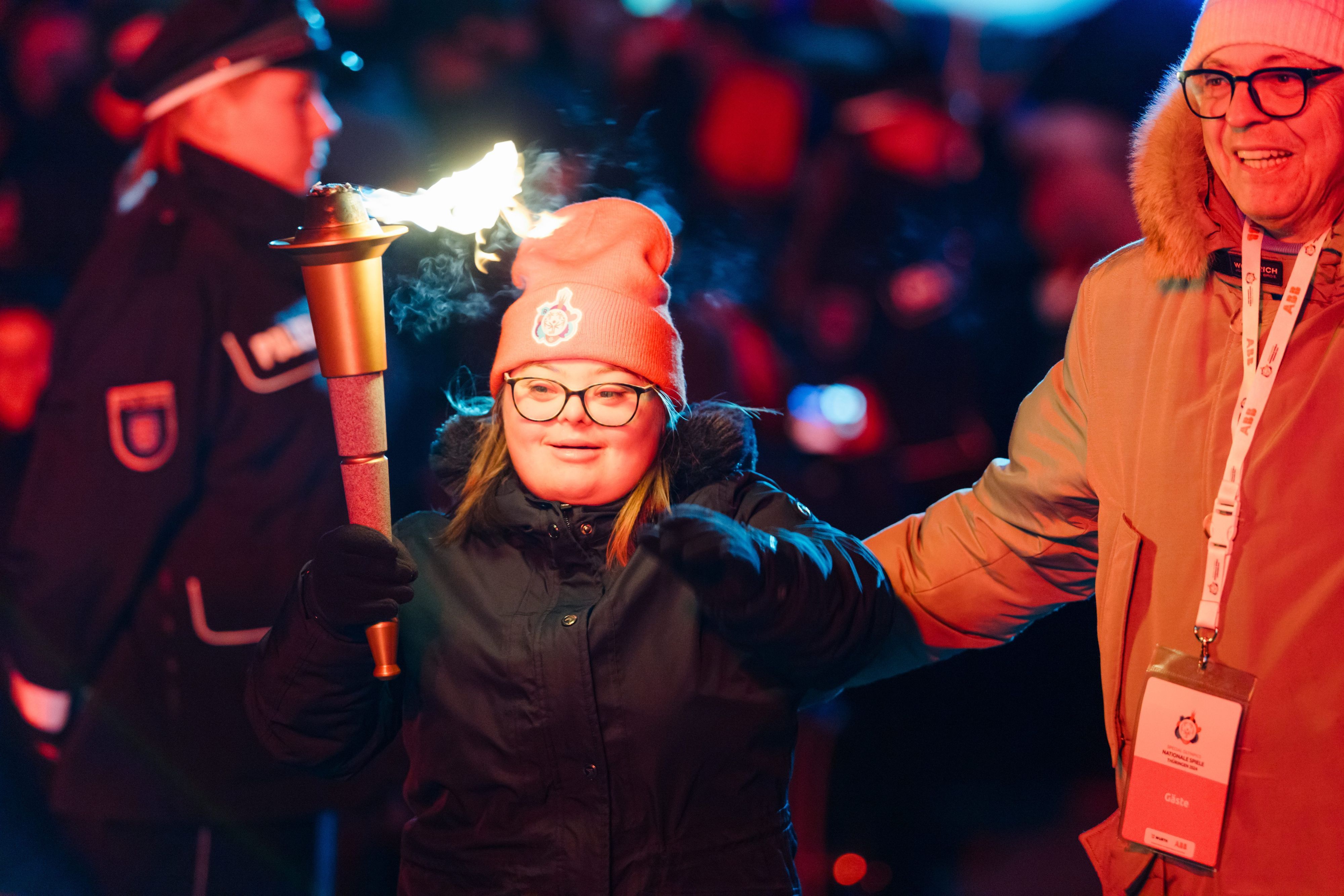Eine Fackelträgerin bringt die olympische Flamme zur Eröffnungsfeier der Special Olympics Nationalen Spiele am Stadtplatz.
