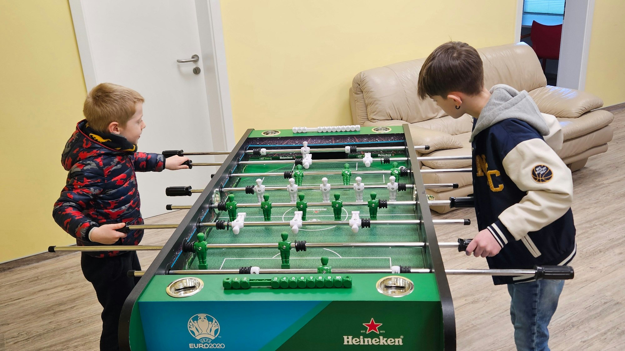 Zwei Jungs spielen an einem Kicker.