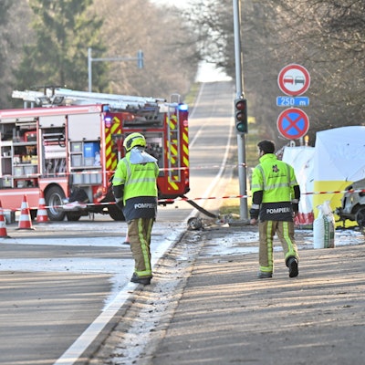 Rettungskräfte des belgischen Notfalldienstes sichern die Absturzstelle eines Kleinflugzeugs im belgischen Spa ab. Zwei Deutsche waren mit ihrer Maschine in ein parkendes Auto auf einer Landstraße geflogen.