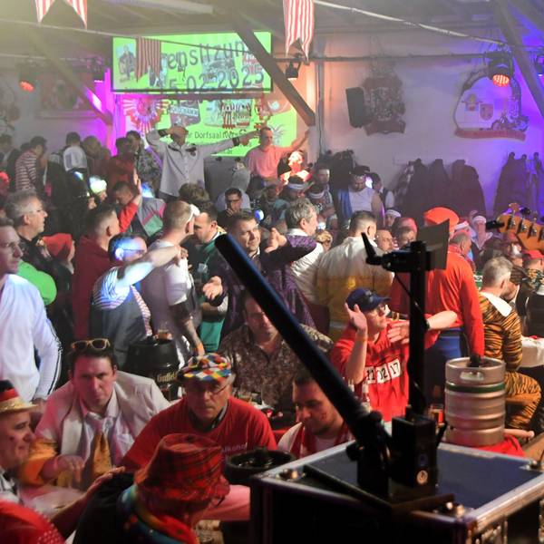 Die Band Lupo ist von schräg hinten zu sehen, vor ihnen das Publikum der Iversheimer Herrensitzung.
